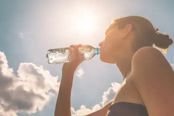 Hydration: The Secret Ingredient for a Toned Stomach and Enhanced Fitness 3 Image of woman drinking water to hydrate Hickstead after run.