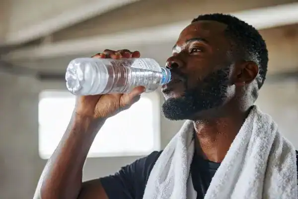 Hydration: The Secret Ingredient for a Toned Stomach and Enhanced Fitness 1 Image of man drinking water to improve hydration Hickstead after work out.